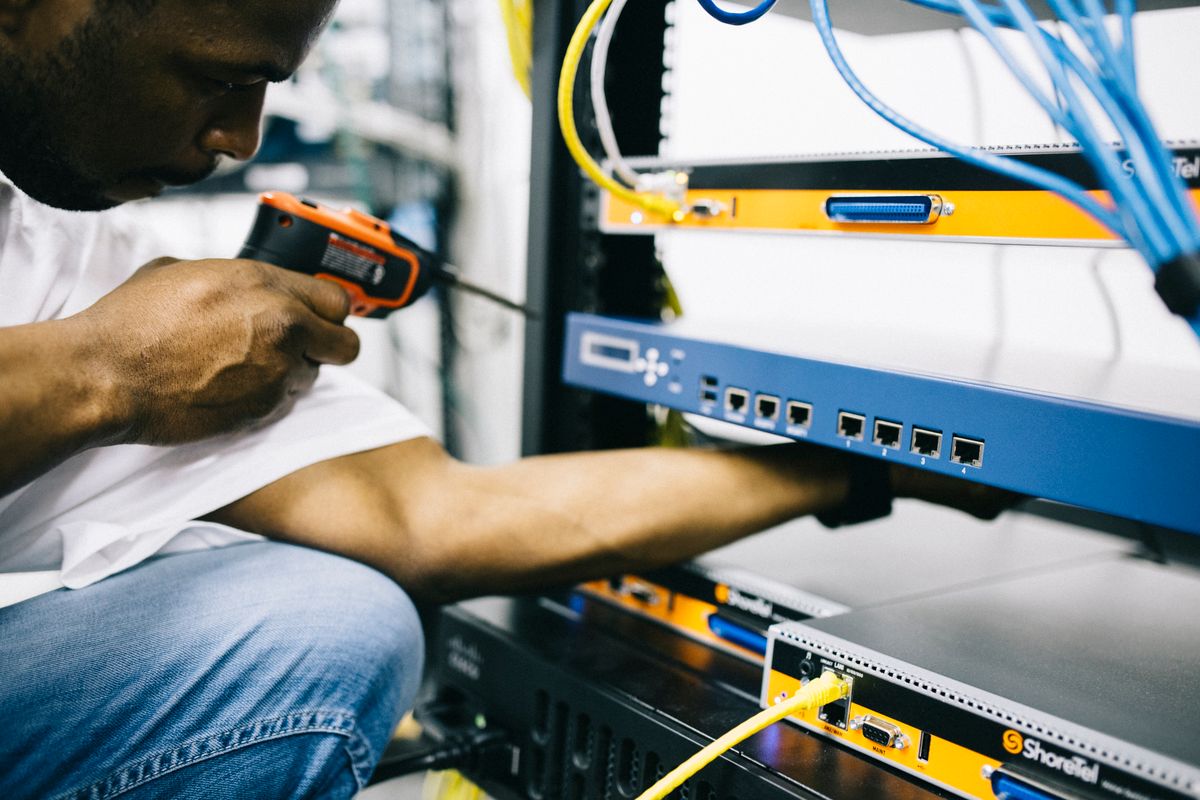 Technician installing network equipment in a server rack